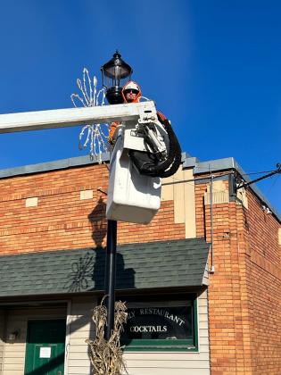 DPW, Mike Swanson putting up Holiday decorations, preparing for Chrstmas In Lights celebration downtown Iron River. Photo by Wendy Graham.